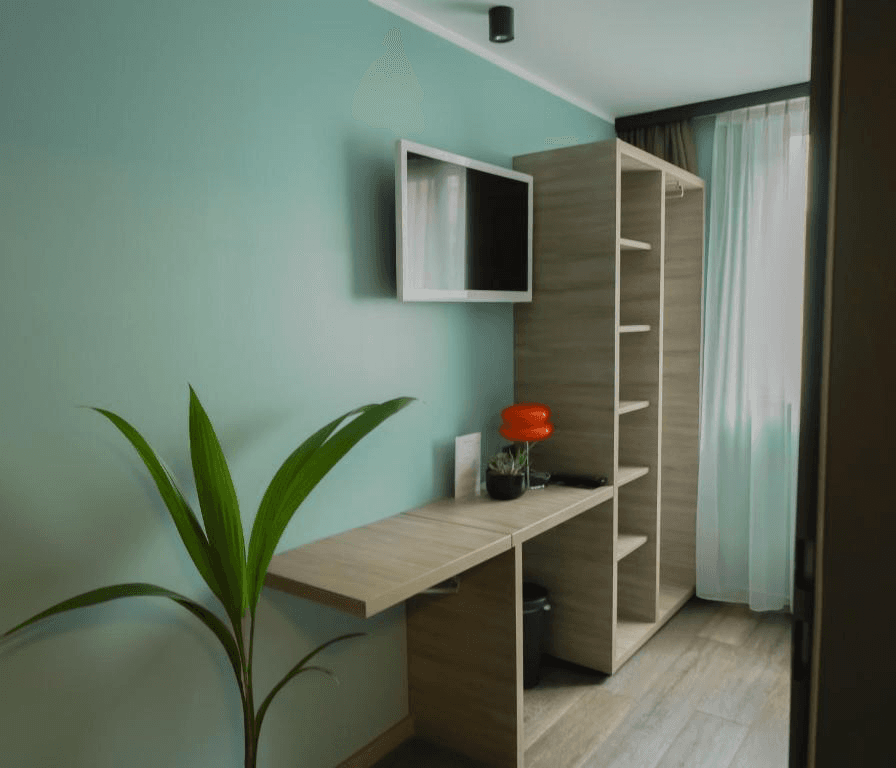 Desk and storage area in the single room at Hotel BEE GREEN Schönbrunn